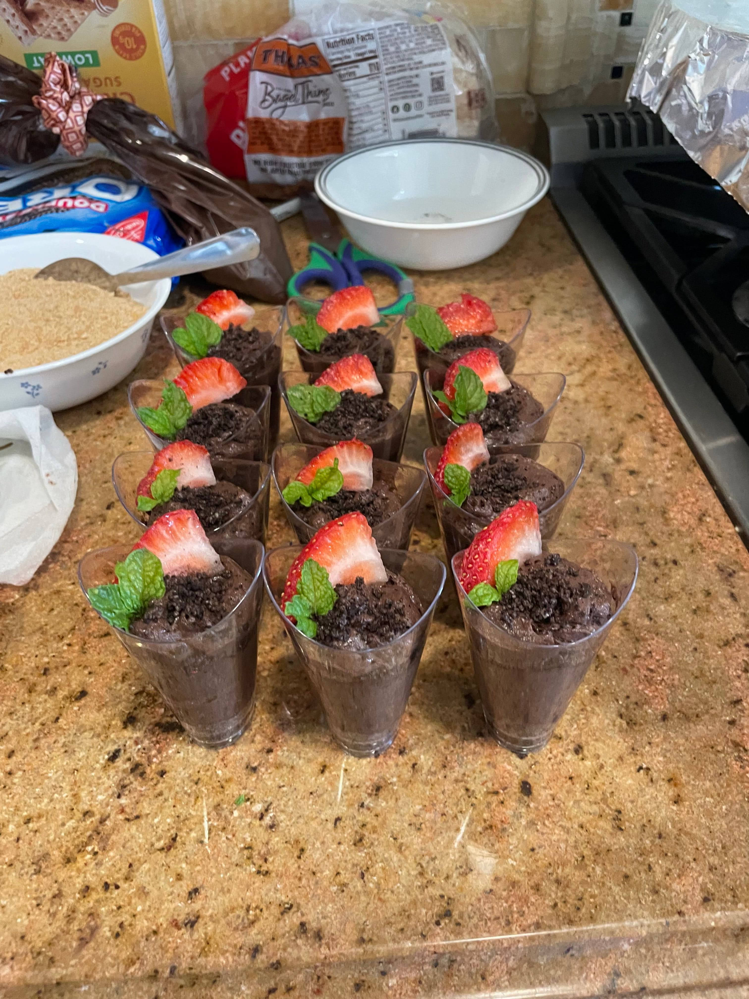 Chocolate dessert shots topped with strawberries and mint